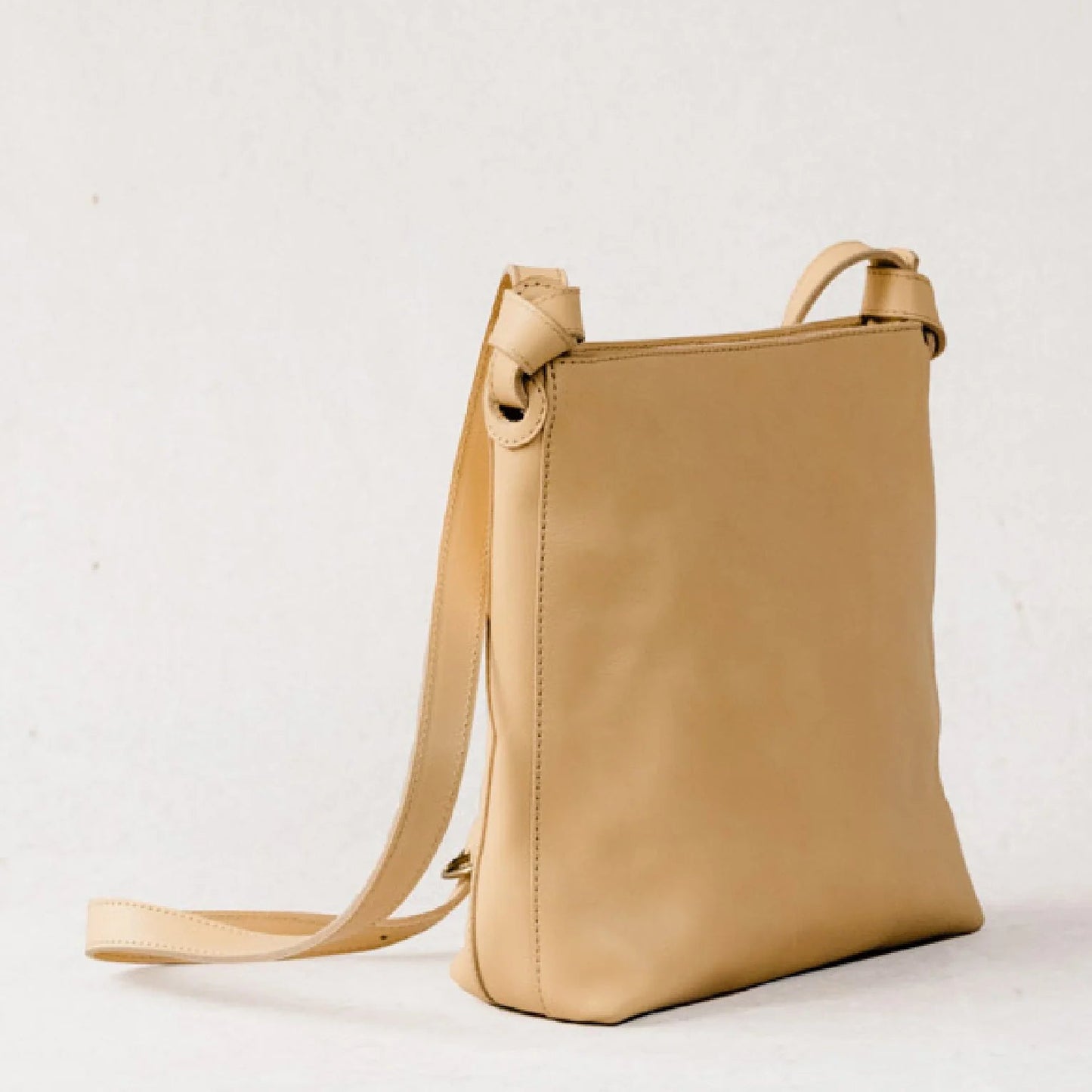 side view of tan leather shoulder bag.