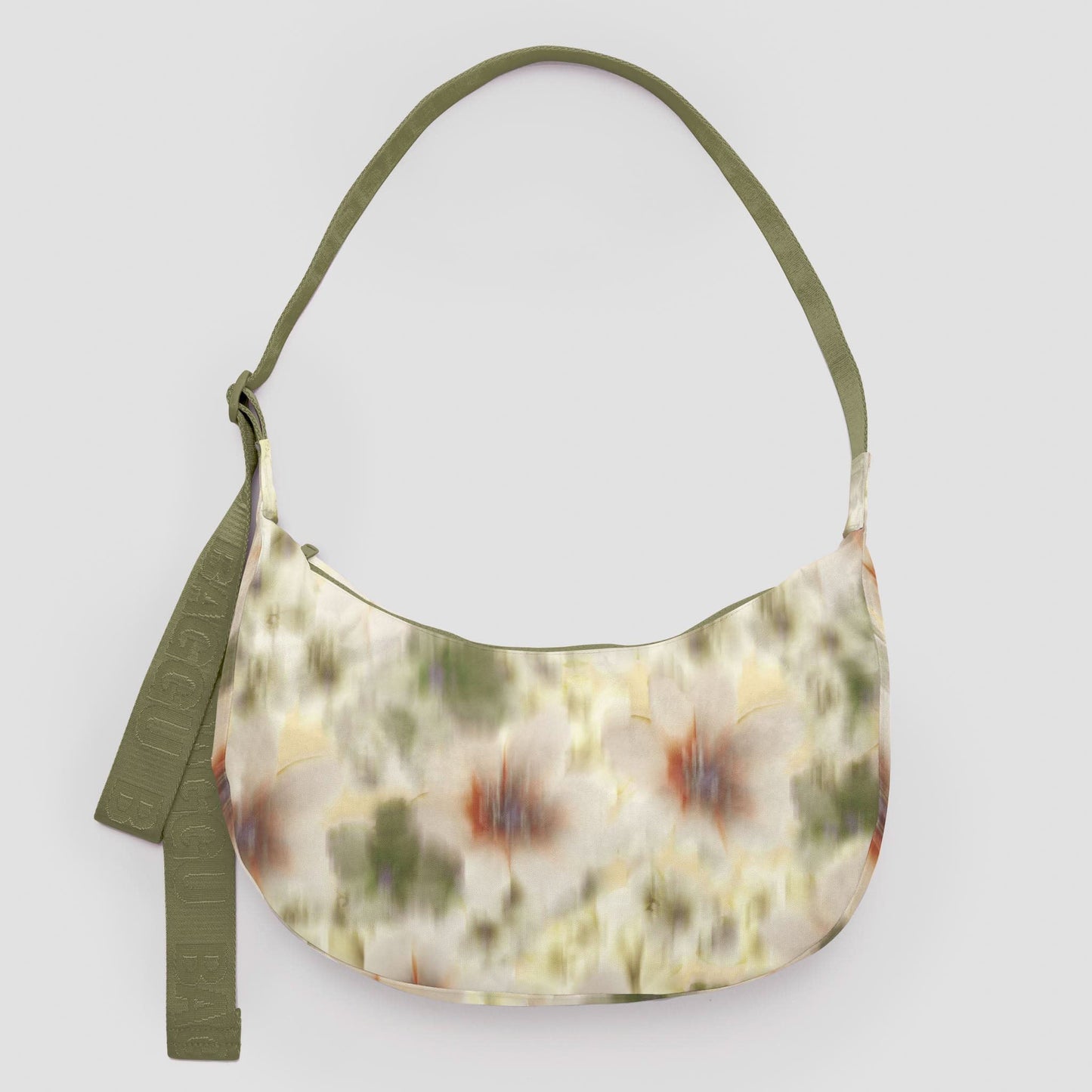 Floral patterned handbag with green strap on a light gray background