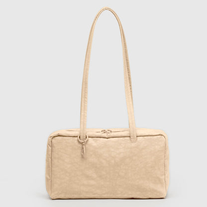 Beige handbag with a strap on a light gray background