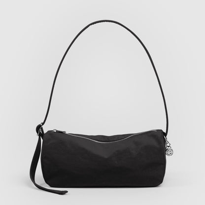 Black handbag with a strap on a light gray background