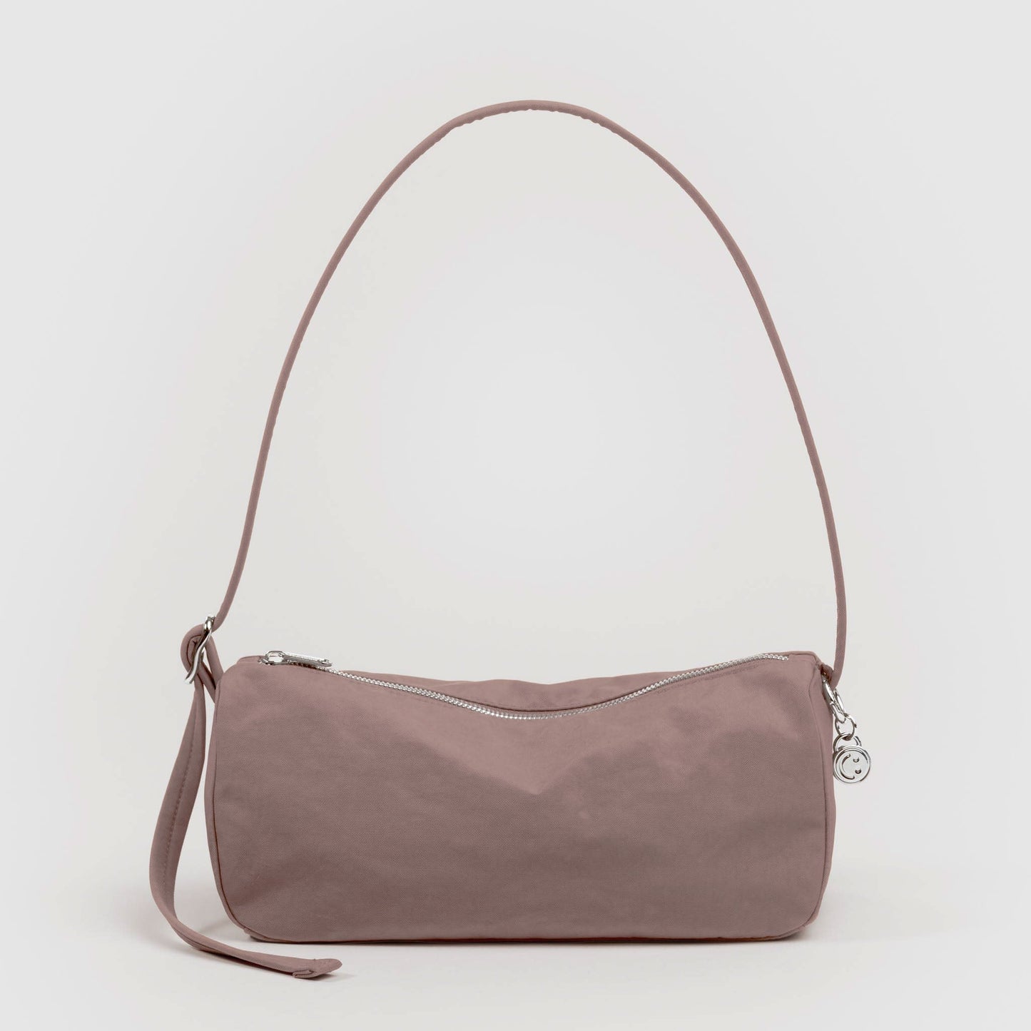 Tan handbag with a strap on a light gray background