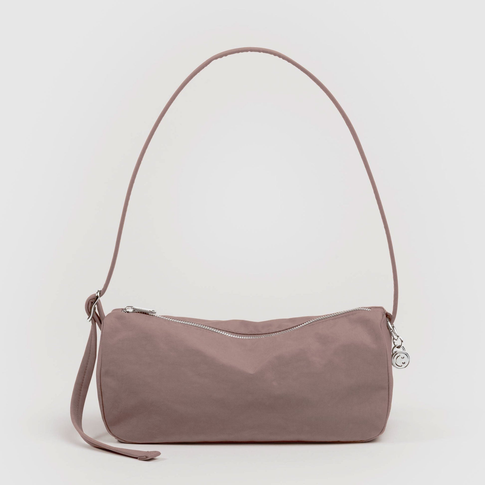 Tan handbag with a strap on a light gray background