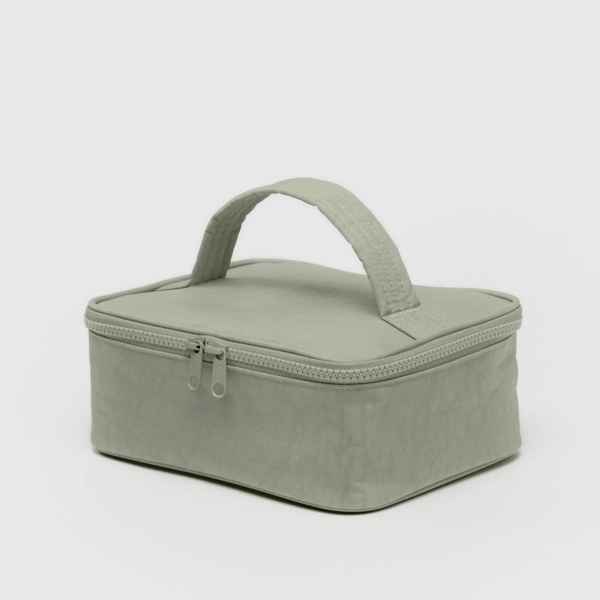 Green rectangular cosmetic case with a handle on a light gray background