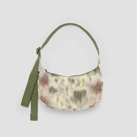 Floral purse with a green strap on a gray background.