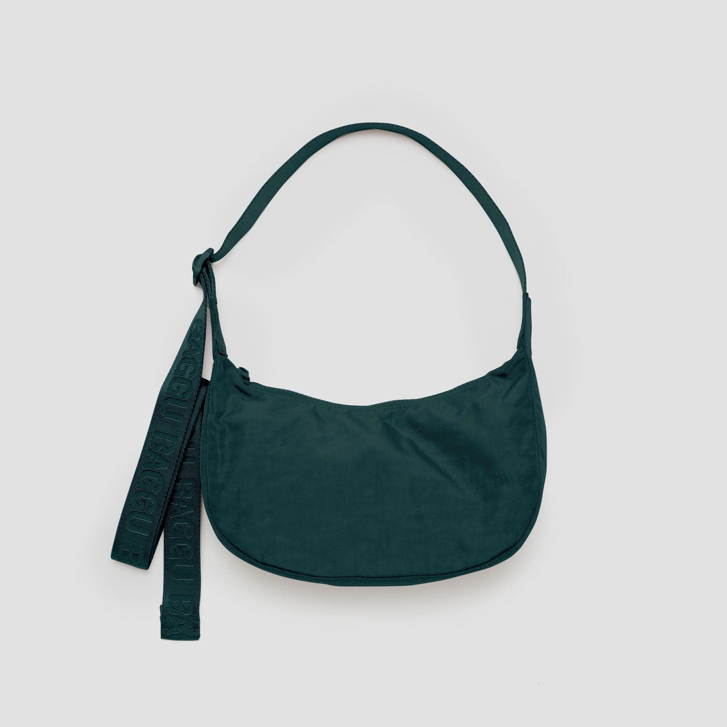 Green handbag with a strap on a light gray background
