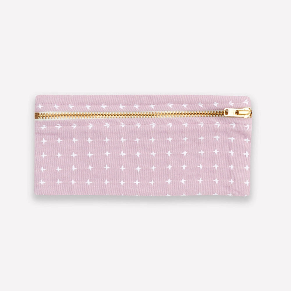 Lilac purple pencil case with white cross stitch pattern and gold zipper on a white background