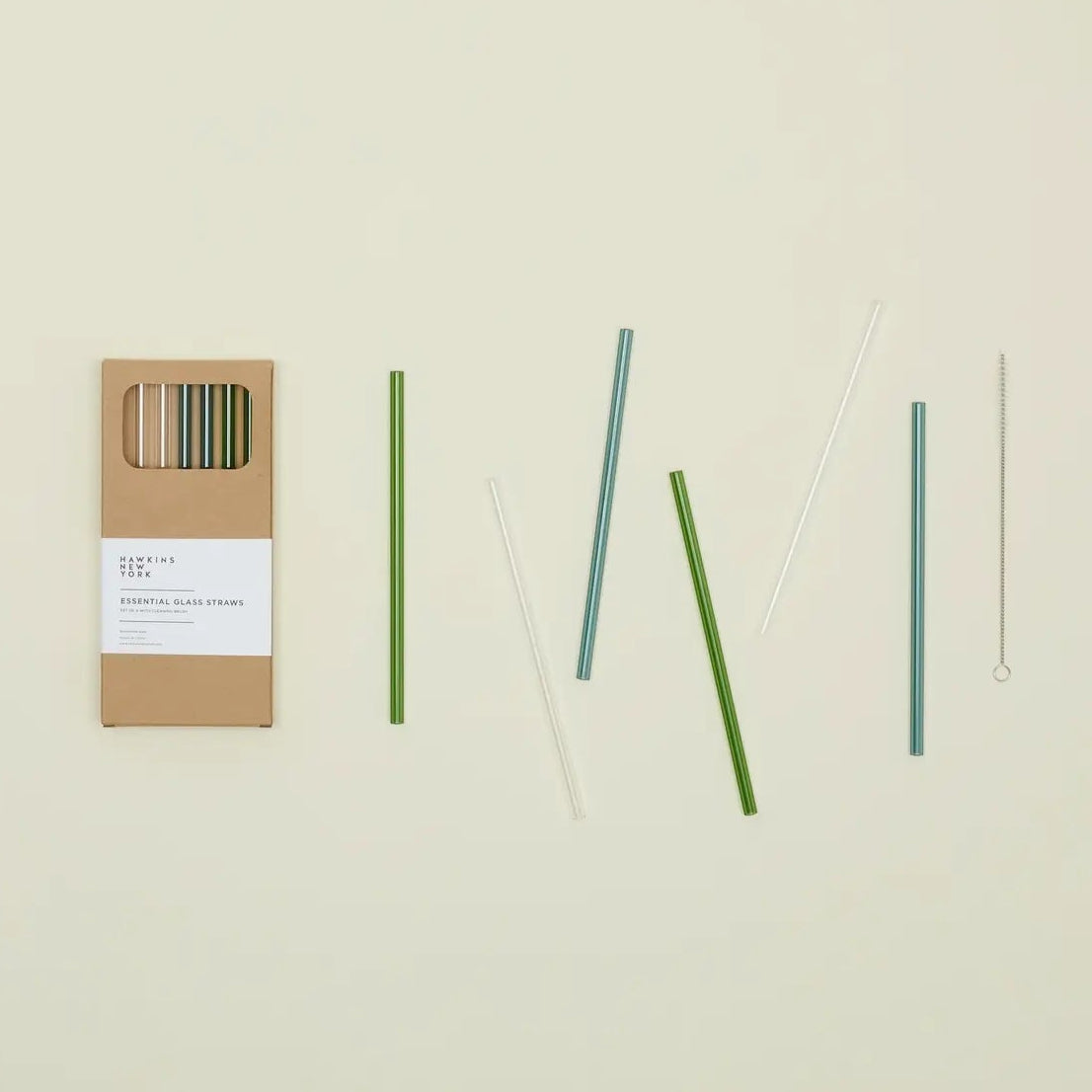 Set of 6 green, blue, and clear straws with a cardboard packaging on a beige background