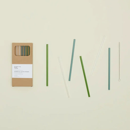 Set of 6 green, blue, and clear straws with a cardboard packaging on a beige background