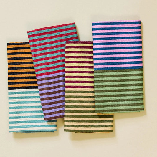Set of colorful striped fabric napkins on a beige background