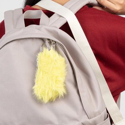 Person wearing a gray backpack with a yellow fluffy keychain