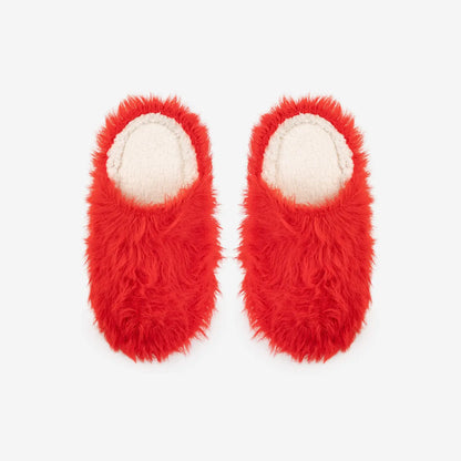 Pair of red furry slippers on a white background