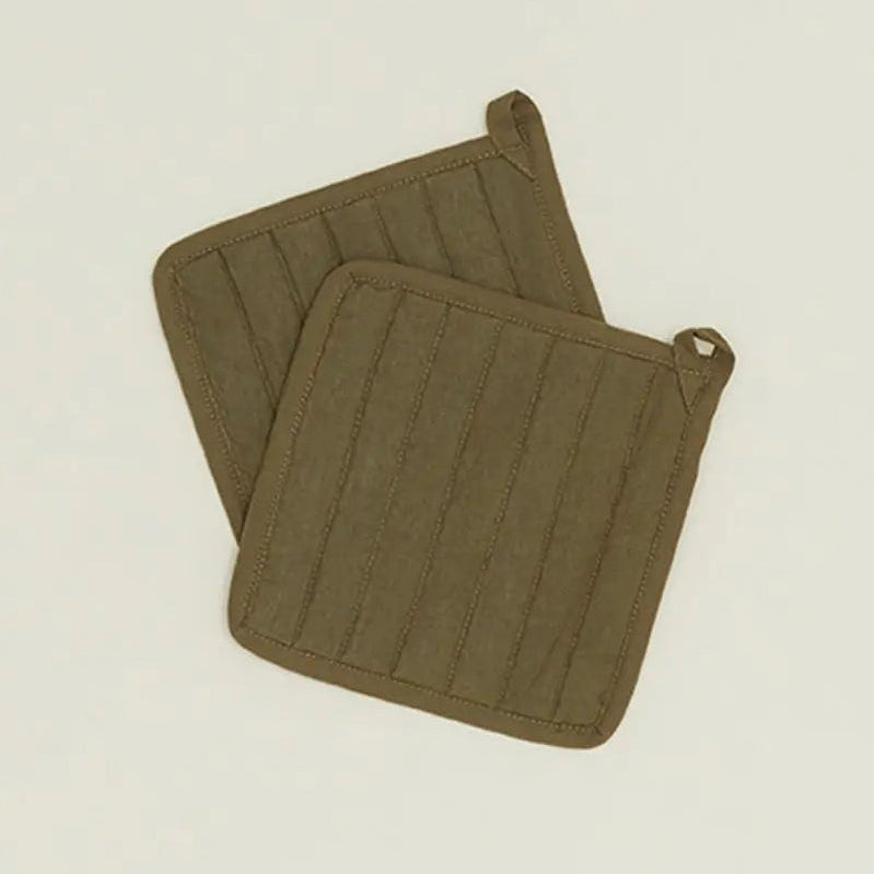 Two olive green pot holders on a beige background