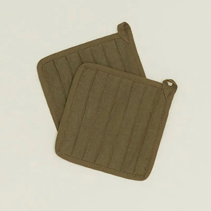 Two olive green pot holders on a beige background