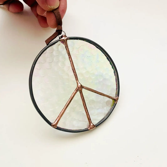 Peace symbol stained glass ornament with iridescent glass and copper lines.