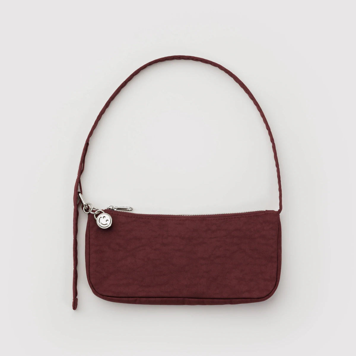 Dark red handbag on a grey background.