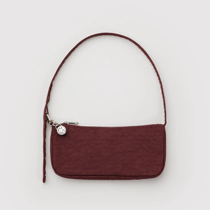Dark red handbag on a grey background.
