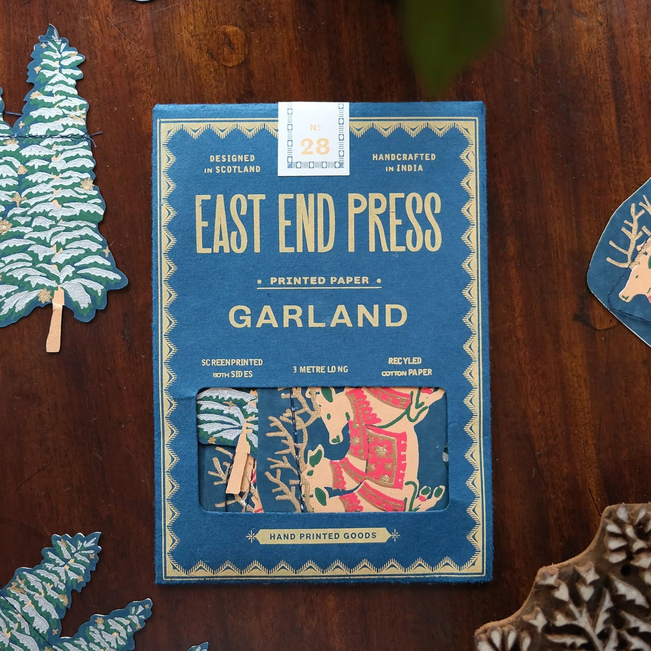 Pack of East End Press Garland on a wooden surface with decorative items.